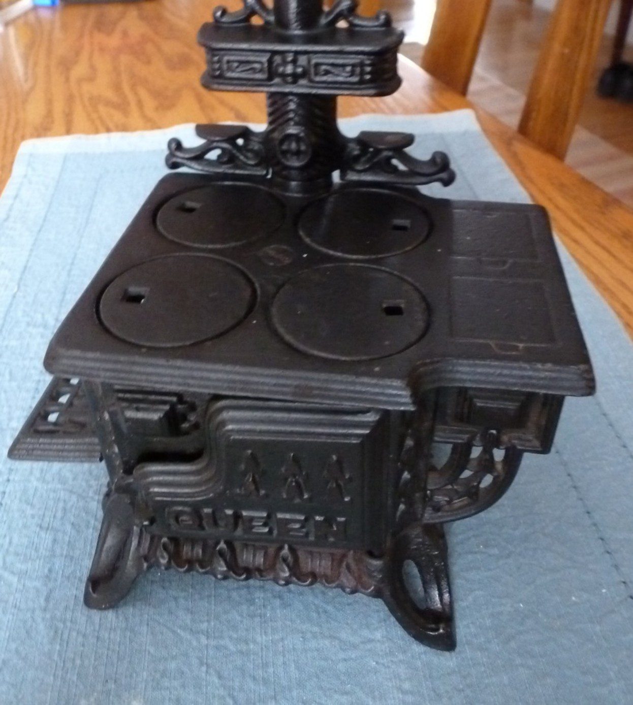 Antique cast iron wood-burning stove with ornate legs and four burner plates.