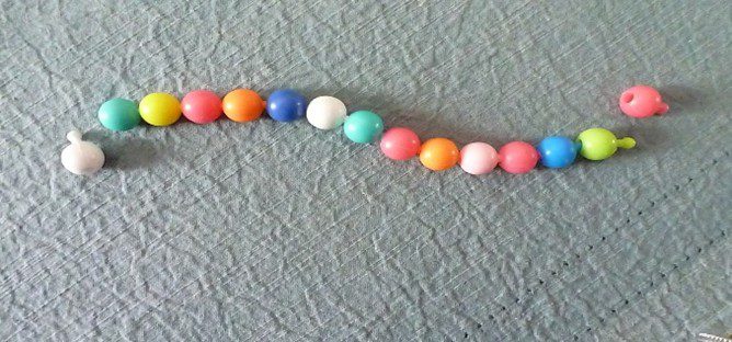 A colorful beaded necklace laid on a textured surface.