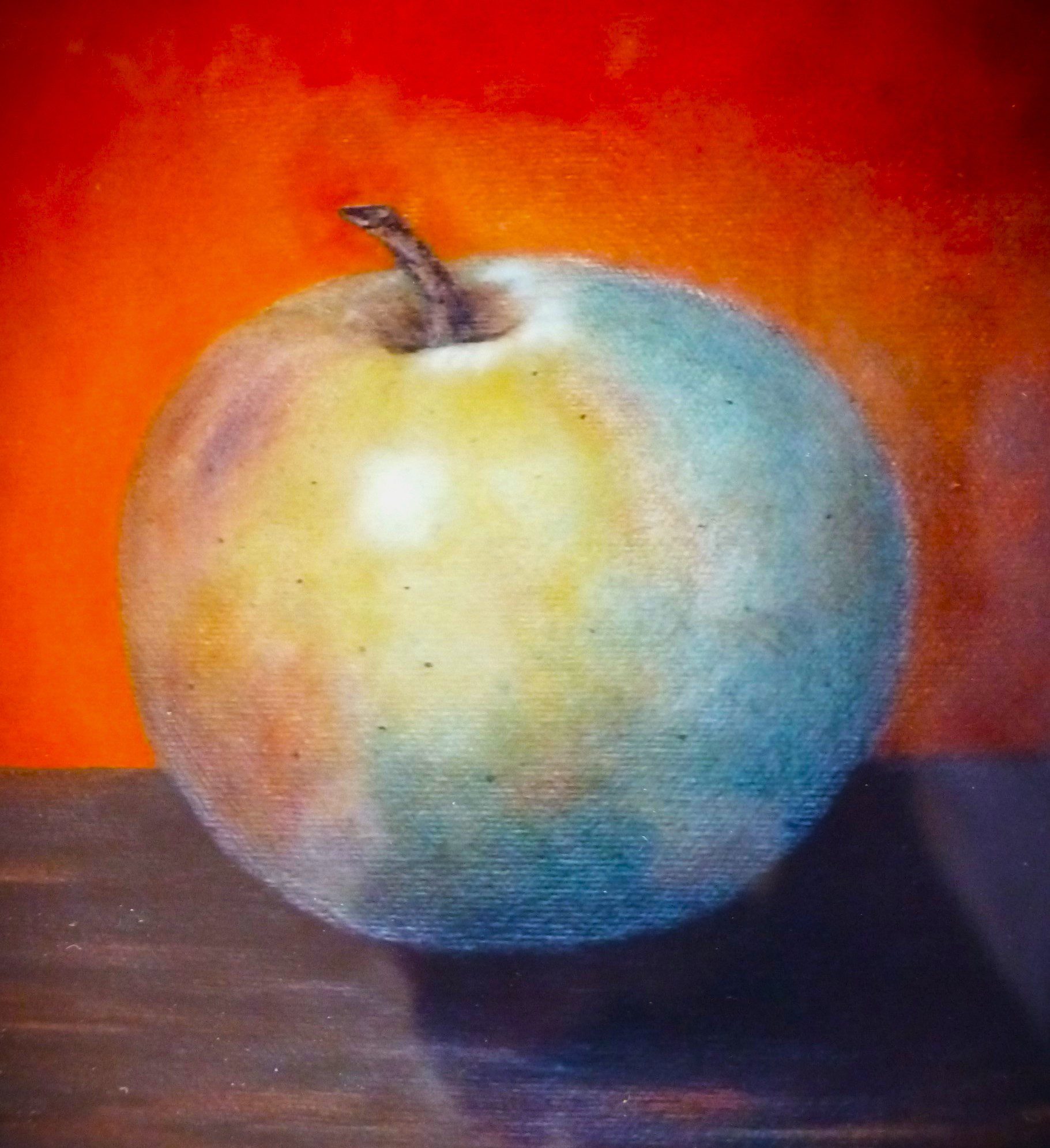 A colorful pumpkin with vibrant hues against an orange background.